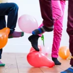 people trying to stamp on the balloons attached to each others ankles