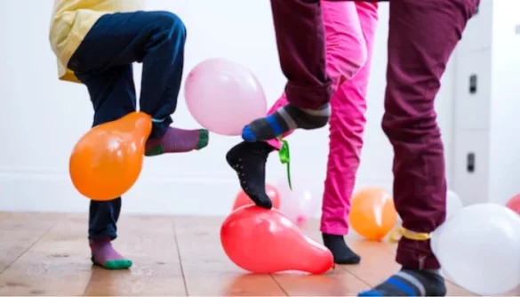 people trying to stamp on the balloons attached to each others ankles