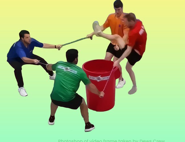 Photoshop image of a video frame of 4 men linked by rope around a dustbin, playing "Don't touch the can"
